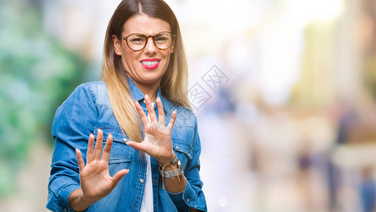 年轻漂亮的女人在模糊的背景下戴着眼镜厌恶的表情图片