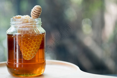 蜂蜜与木蜂蜜勺在木桌图片