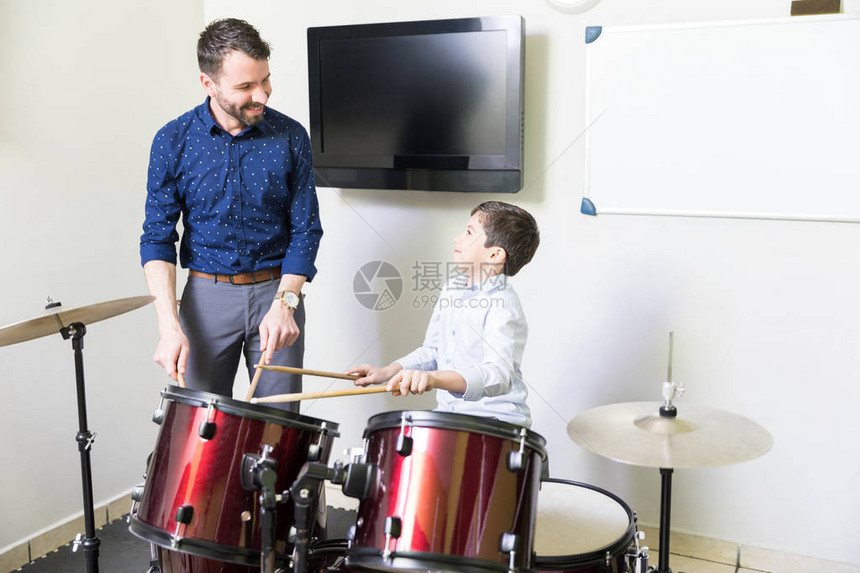 微笑的音乐老师用他的鼓演奏图片