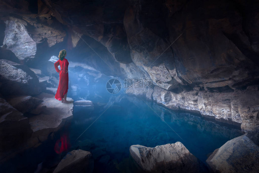 冰岛风景美丽的艺术图片女士穿着红衣骄傲地站在神秘和迷雾的洞穴图片