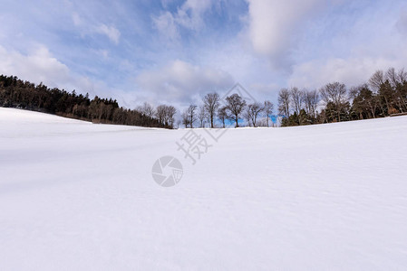 田园诗般的农田乡村与云彩和山峰的彩色乡村雪冬景观图像图片