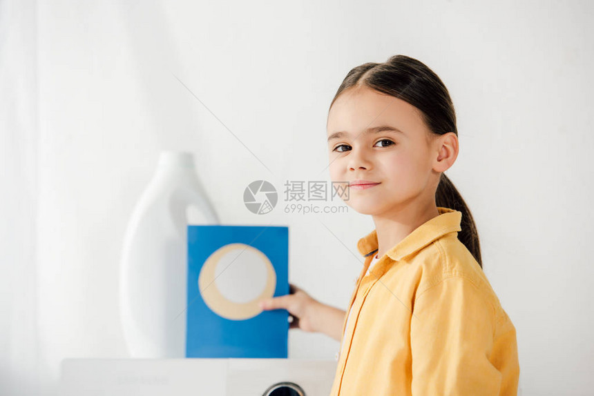 在洗衣房中用洗衣粉和洗衣粉对儿童有图片