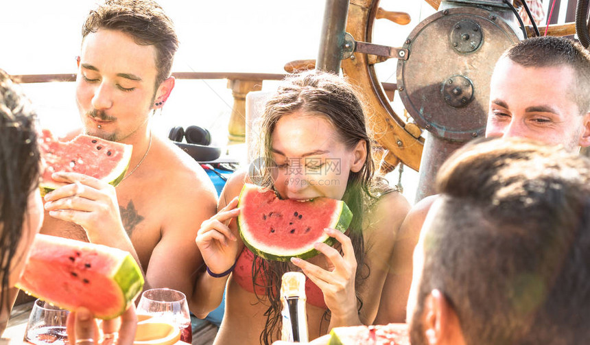 快乐的千禧朋友在帆船派对上玩西瓜桑格利亚汽酒和香槟图片