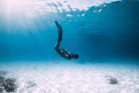 女子自由潜水滑翔在沙海上有鳍图片