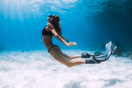 女自由潜水者游过沙海有鳍图片