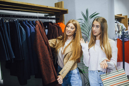 两名年轻妇女在现代时装店购物图片