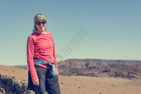 阳光明媚的天在火山荒地上冒出迷人的黑发美女图片