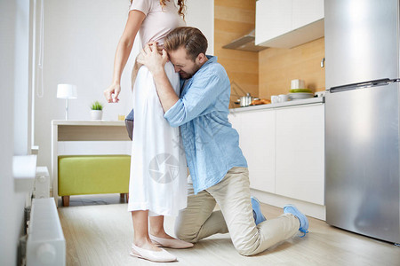 年轻谦道歉的男人拥抱妻子求她不要离开图片