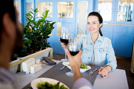快乐的一对年轻夫妇坐在餐厅吃饭和庆祝家庭节日时图片