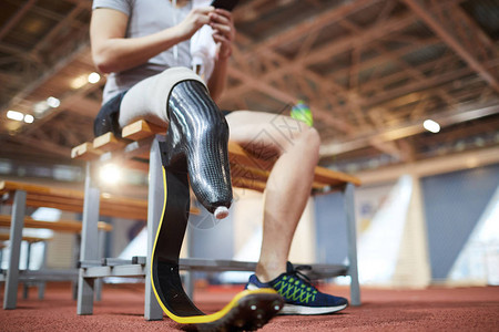 年轻残奥运动员在体育场训练后休息的右腿残疾图片