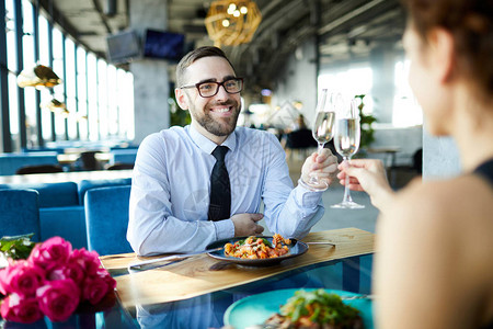 年轻快乐的男人在餐厅浪漫约会时用长笛和女友的长图片