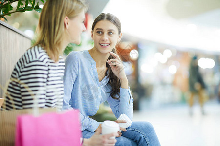 两个休息的女生在大型现代商场闲聊而图片