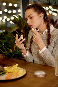 在咖啡馆看智能手机屏幕时图片