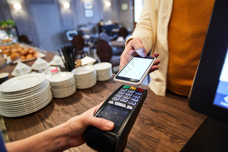 咖啡馆的一位客人借智能手机付费图片