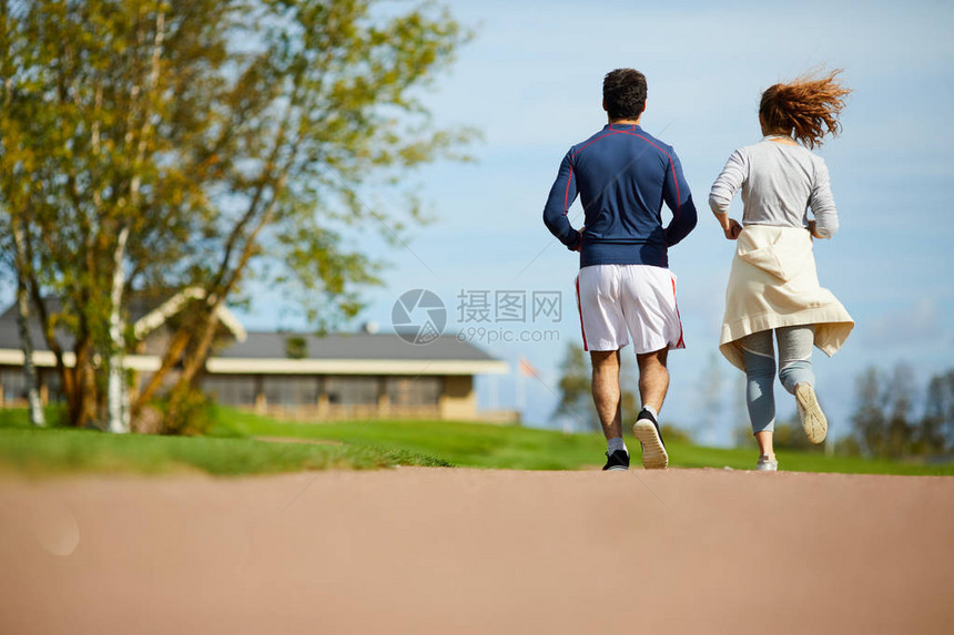 夏季早上在农村环境跑步的年轻活跃夫妇背影图片