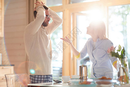 年轻有情感的白种夫妇在日落的家厨房里图片