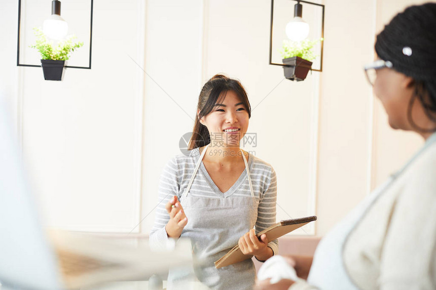 带笔记的亚洲年轻女在工作单位向同事解释工作时段图片