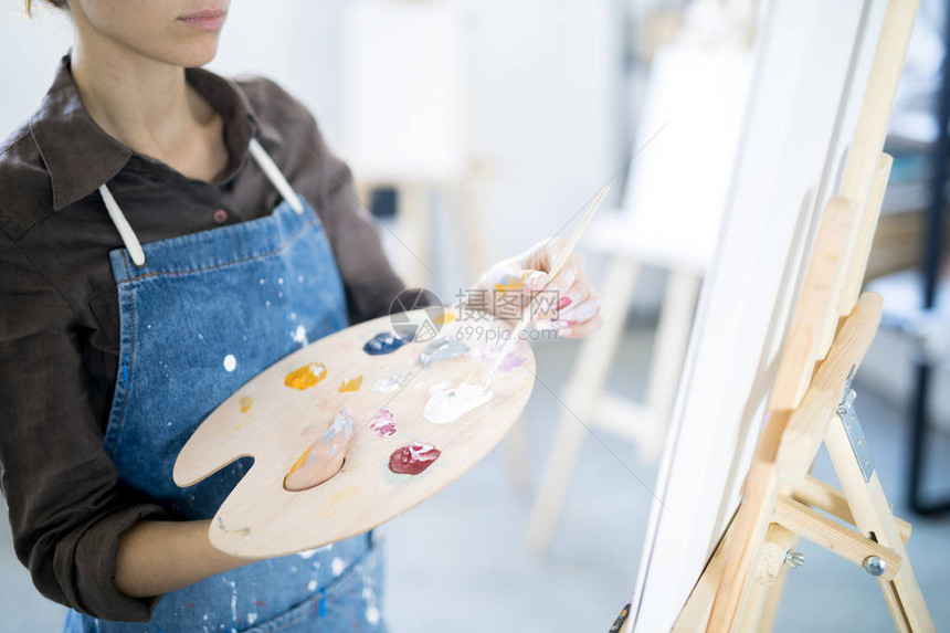 女画家从调色板上取色在工作室图片