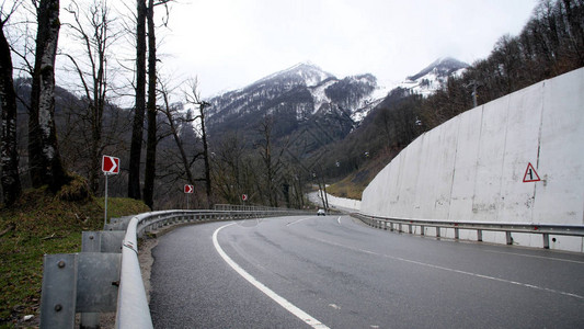 打开森林山区的乡间小路交通过汽车山蜿蜒的道路穿过森林在多云天图片