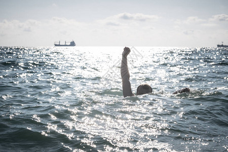 溺水者在海中求救的单手伸出水面图片