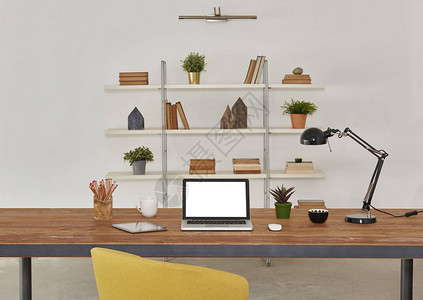 笔记本电脑和平板电脑在木桌和办公室内部与辅助书咖啡和植图片