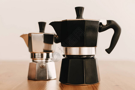 木桌上的钢和黑色间歇泉咖啡壶替代咖啡冲泡方法用于替代咖啡的时图片