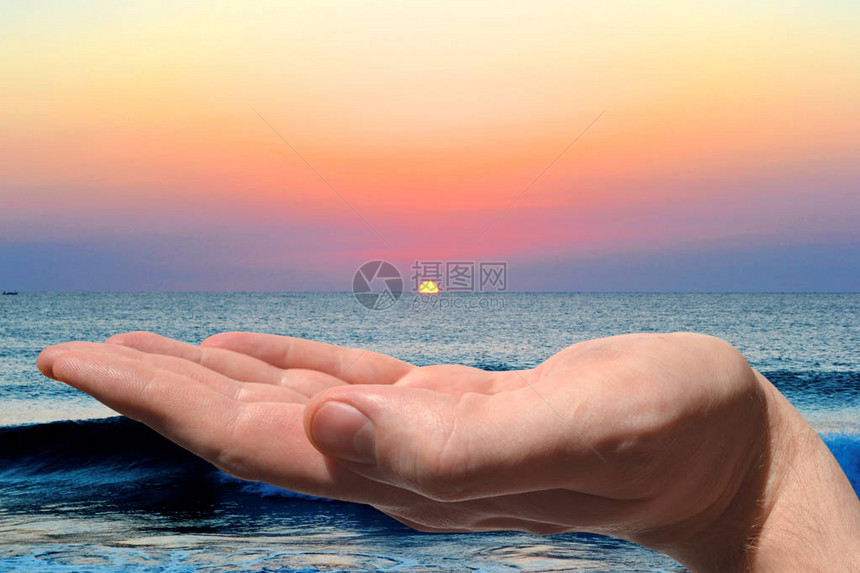 手和夕阳的天空海洋图片