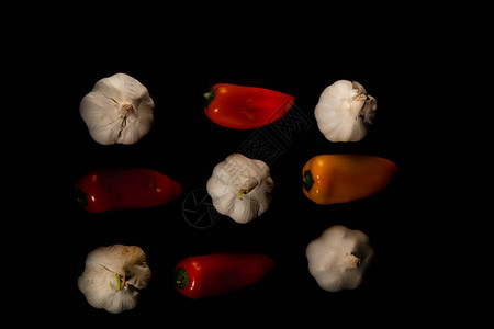 在黑色背景上特写不同颜色的迷你甜辣椒和大蒜健康食品的概念健图片