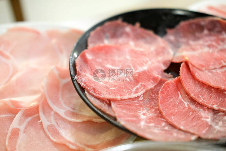 用于Shabu和Sukiyaki日本风格的原始红牛肉和生猪肉片图片