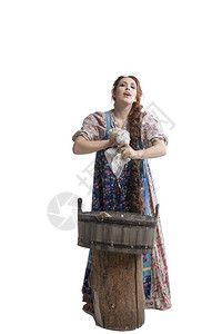 身着民族服装的俄罗斯青年妇女用木浴缸洗床单图片
