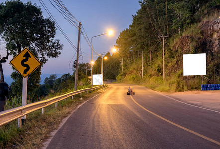 黄昏时分山上的曲线路灯图片