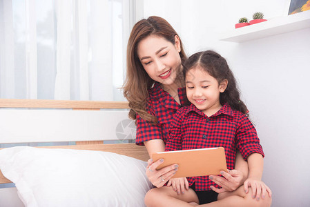 美丽的亚洲母女在家一起使用平板电脑图片