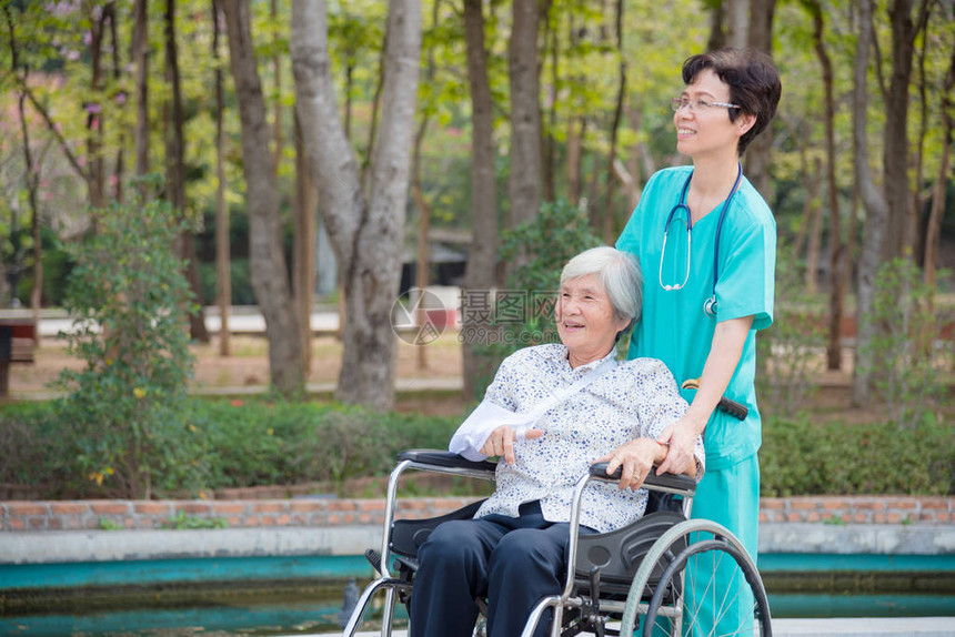 快乐的亚洲高龄妇女坐在轮椅上护士在养老图片