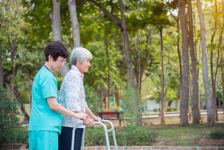 在医院公园的护士帮助下行走的残疾老年亚洲老龄妇图片