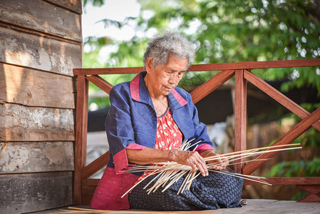 亚洲生活在家工作的老妇人祖母在农村生活认真生活泰国农村人在木屋上编图片