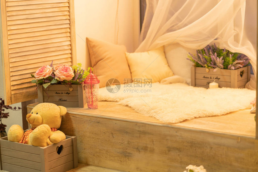 窗台上放着枕头白色毛皮泰迪熊和鲜花图片
