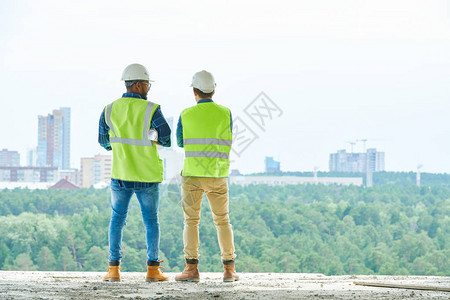 站在建筑工地和欣赏现代城市的景象上图片