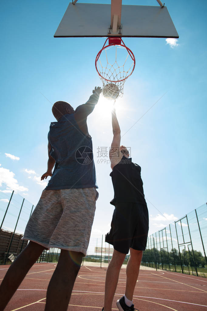 两名青年男子在户外法庭打篮球的行动肖像图片