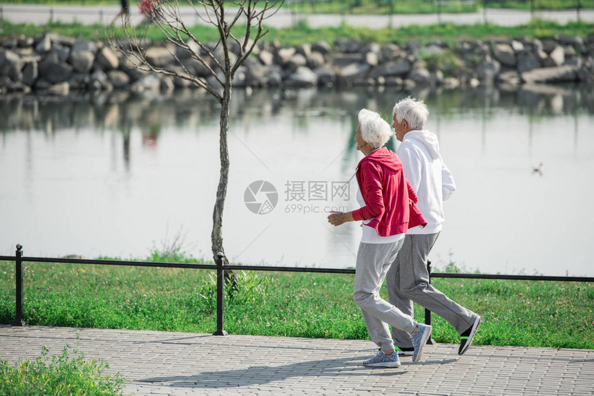 沿湖边公园复制空间运行的活跃老年夫妇全侧图片