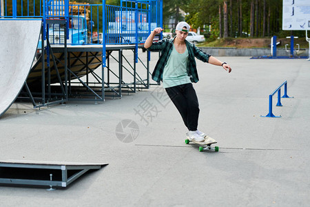 当代青年男子在滑板公园复制空间的长板室外运图片