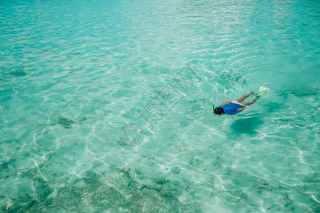 在马尔代夫令人惊叹的绿松石海洋中游泳的人图片