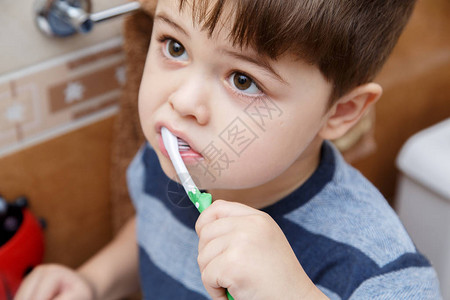 小可爱男孩在浴室里刷牙图片