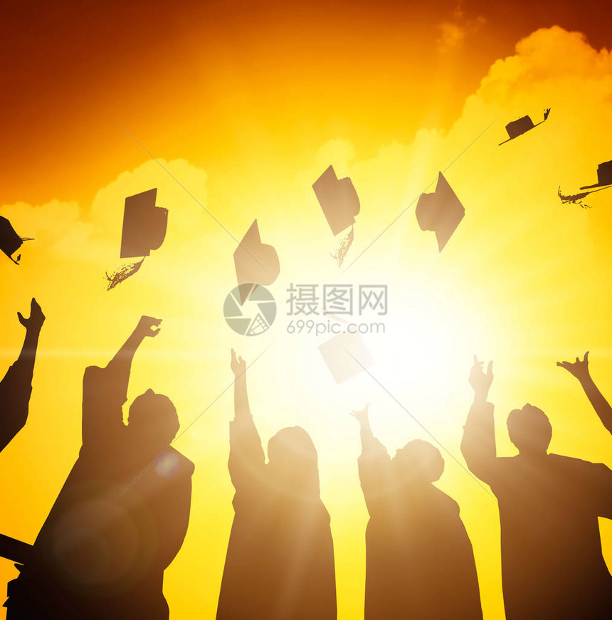 快乐的学生在空中扔毕业帽图片