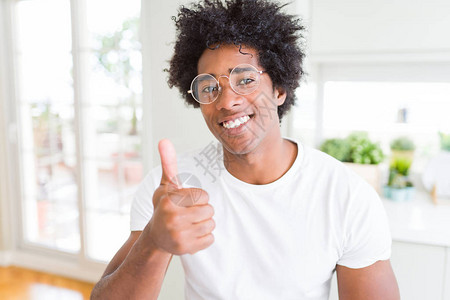 身戴眼镜的非裔美国人用手举起手来玩乐拇指图片