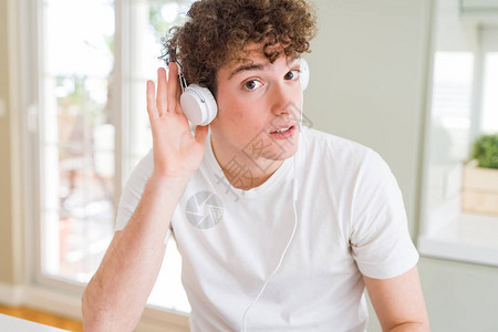 年轻人在家中听音乐时戴耳机微笑图片