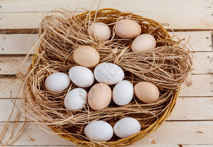 新鲜的鸡蛋放在篮子里干草图片