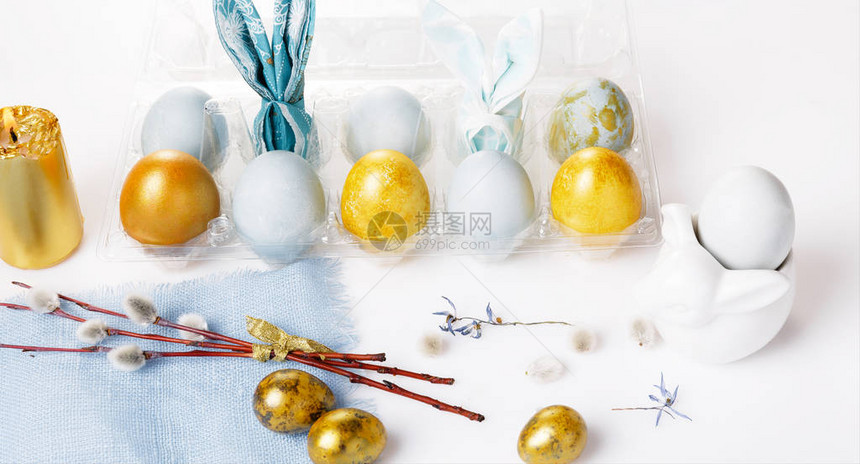 盘子和餐具蓝色金色的复活节彩蛋猫柳和春花图片