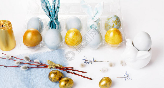 盘子和餐具蓝色金色的复活节彩蛋猫柳和春花图片