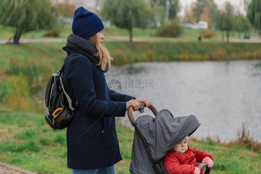 一名妇女带着一辆婴儿车在公园走在公园一图片