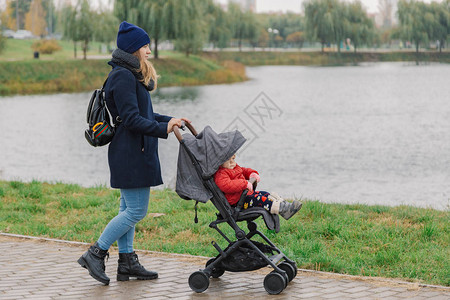 一名妇女带着一辆婴儿车在公园走在公园一图片